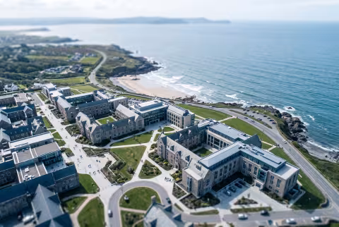 Aerial-style view of the coastal campus cluster — Landing page imagery, establishing hero.